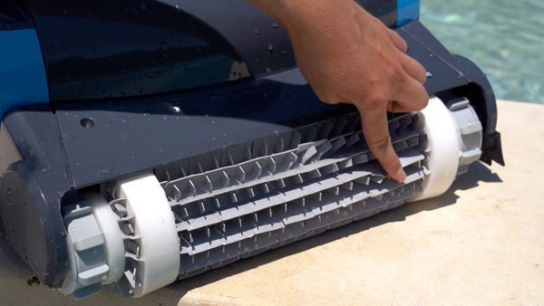 Hand touching the scrubbing brush on the Dolphin Premier