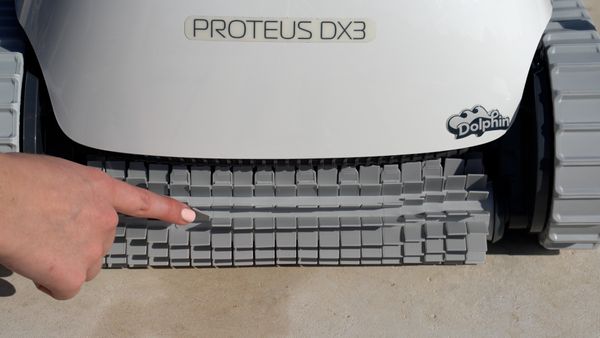 Hand touching the cleaning brush on the Dolphin Proteus DX3