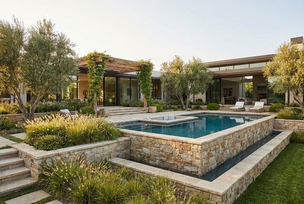 Above-ground pool surrounded by ornamental grasses and shrubs