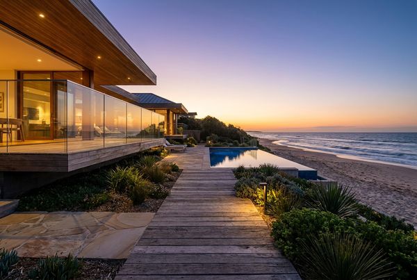 Beach entry pool glowing at dusk with lit shallow shelf and warm lighting