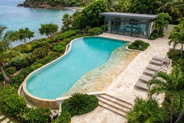 Aerial view of a curved beach entry pool with a wide shallow shelf