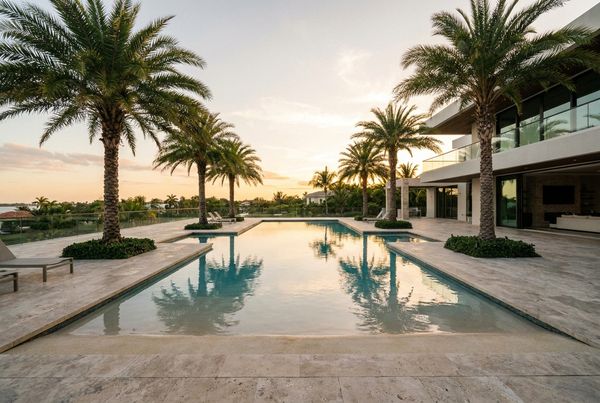 Beach entry pool with warm pebble finish and a curved sandy-toned shelf