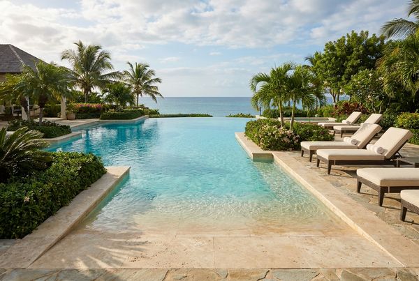 Freeform beach entry lagoon pool with a natural boulder edge