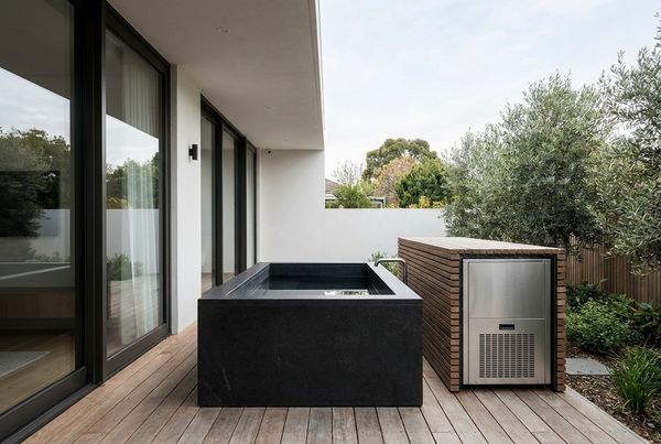 Cold plunge pool with a visible chiller unit beside it