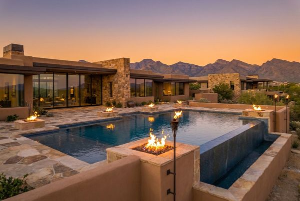 Desert pool with fire features glowing beside the water