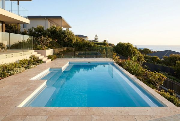 Fiberglass pool with a molded bench and steps and clear blue water