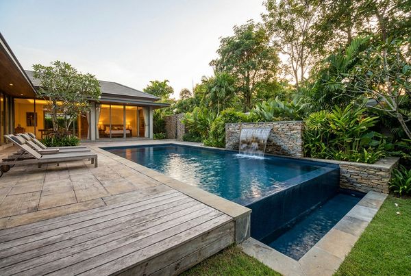 Fiberglass pool with a bubbling water feature spilling into the shell