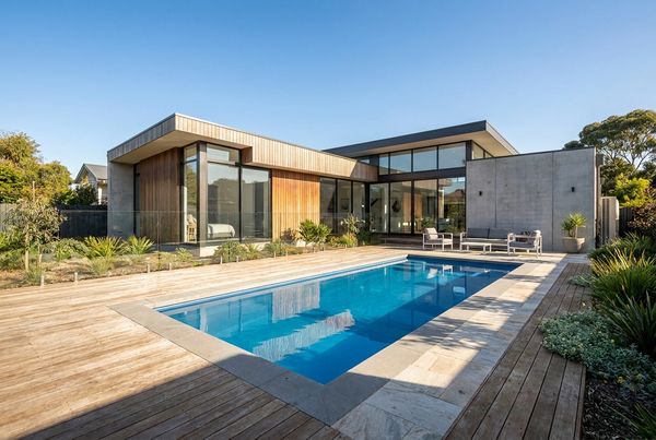 Fiberglass pool set beside a clean-lined modern home