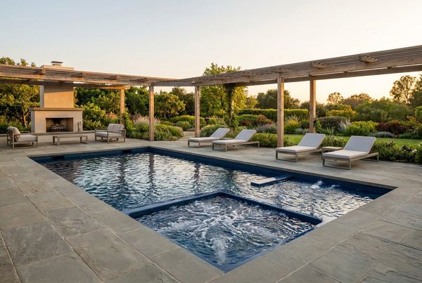 Fiberglass pool with spa jets bubbling along a molded bench