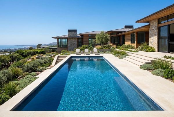 Fiberglass pool with an attached raised spa and spillover