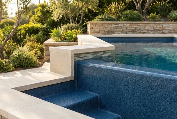 Fiberglass pool bordered by a wide paver deck