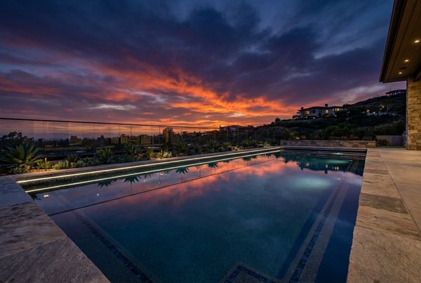 Fiberglass pool in a suburban backyard with a lawn border