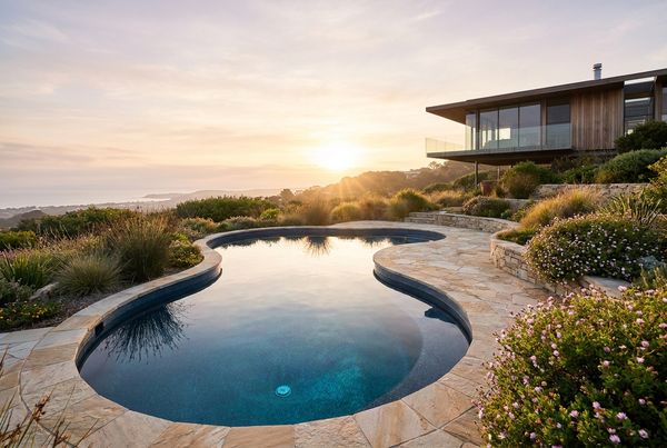 Fiberglass pool with warm evening lighting and lounge chairs