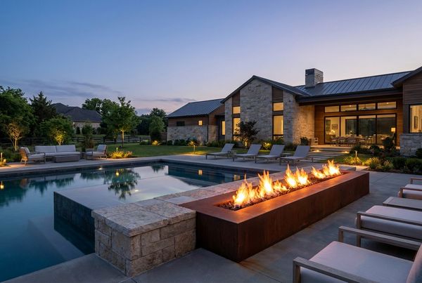 Fire pit flames reflecting across a dark pool surface at night