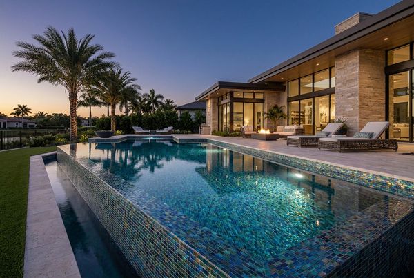 Luxury glass tile pool lit and glowing at dusk