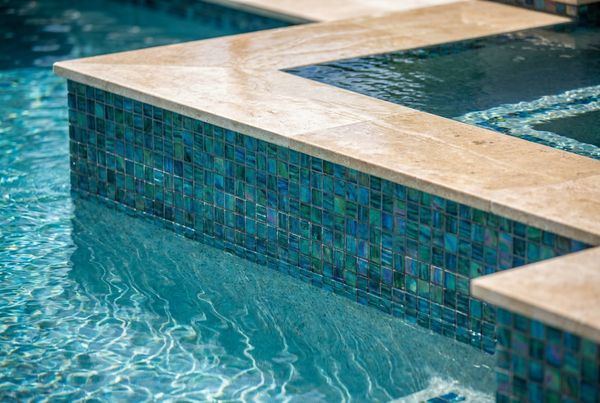 Luxury glass tile pool glowing at dusk