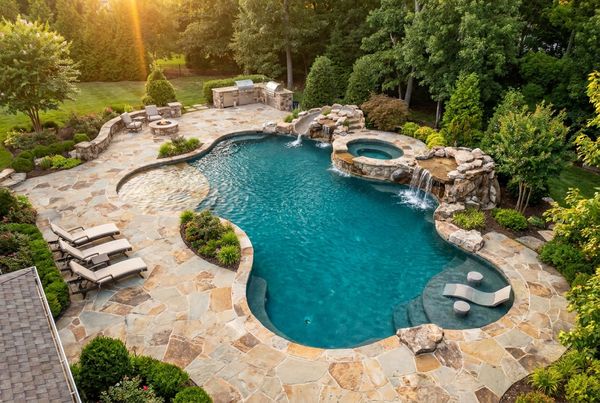 Custom gunite pool with a wide tanning ledge and umbrella sleeve