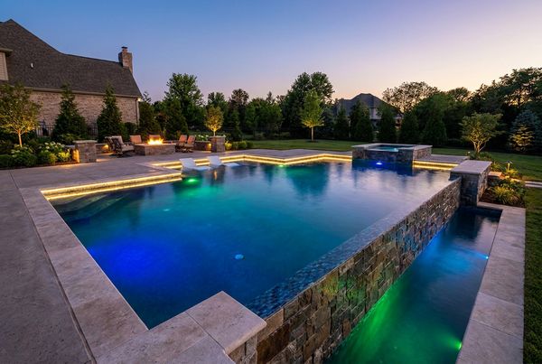 Dark pebble-finish gunite pool reflecting the sky like a mirror