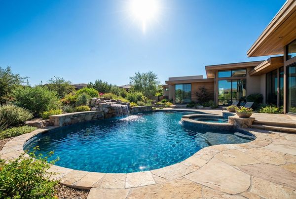 Gunite pool with a sheer-descent waterfall and vanishing edge