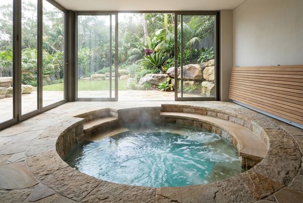 Sunken in-ground hot tub set flush into a stone patio