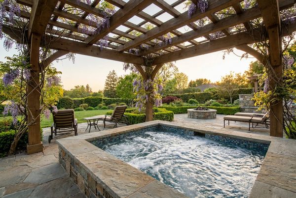 Hot tub under a slatted timber pergola with hanging lights