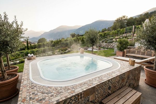 Hot tub with a dark tile surround and integrated bench
