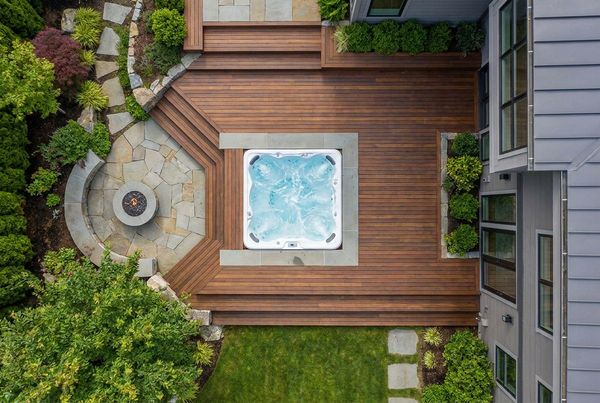 Hot tub surrounded by ornamental grasses and evening lighting