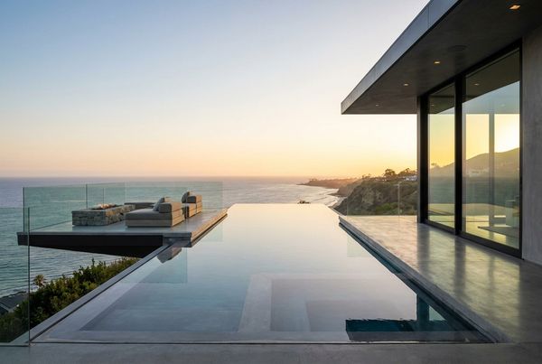 Infinity pool with a fire feature nearby