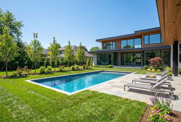 Inground pool surrounded by fresh sod and young landscaping