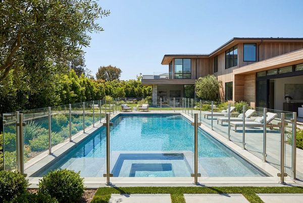 Family pool enclosed by a safety fence with self-closing gate