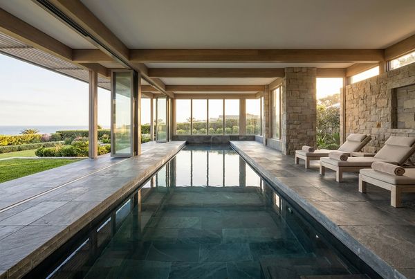 Lap pool with a dark tile interior reflecting the sky along its length