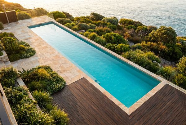 Aerial view of a long narrow lap pool beside a modern house