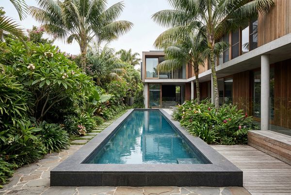 Lap pool with a sheer-descent waterfall along a raised wall