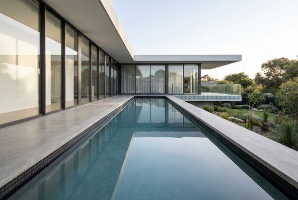 Lap pool running beside a house with flush stone coping