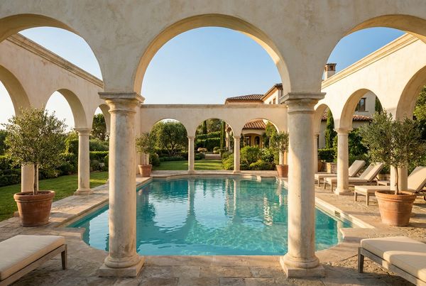 Stucco arches beside a warm-lit Mediterranean pool