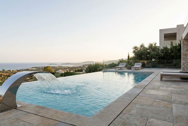 Modern pool with a wide sheer-descent water feature spilling into it