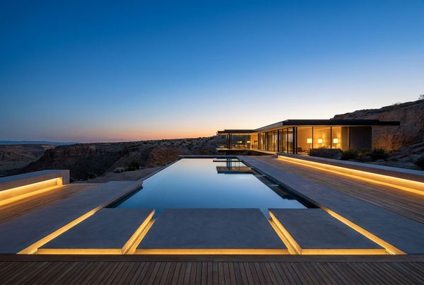 Modern pool lit with integrated lighting at dusk