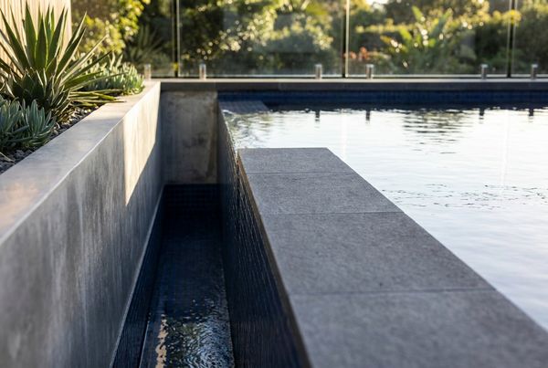 Minimalist concrete pool with flush deck coping