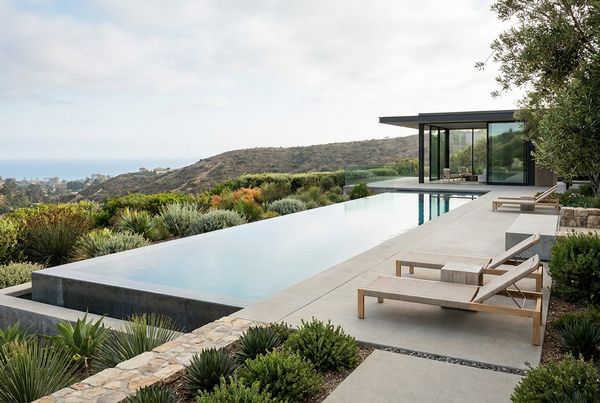 Modern pool at dusk with architectural landscape lighting