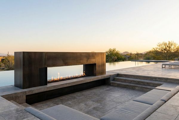 Modern linear outdoor fireplace with a wide low firebox on a contemporary patio
