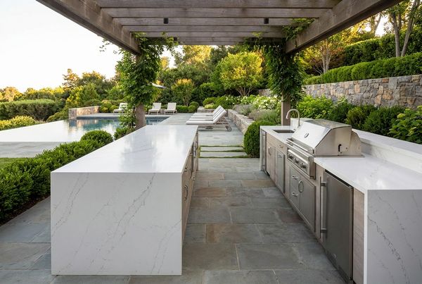 Modern outdoor kitchen with a waterfall-edge quartz counter and clean lines