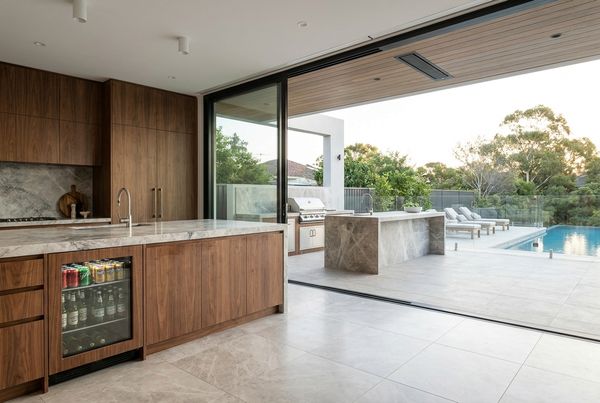 Outdoor kitchen with a stainless beverage fridge built into the island