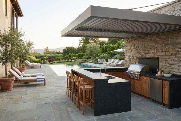 Straight-run outdoor kitchen with a built-in grill and counter against a wall