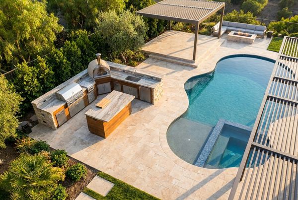 Poolside outdoor kitchen under a modern pergola with string lights