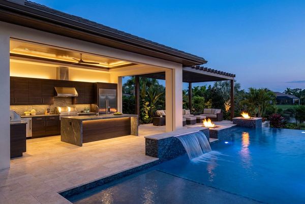 Poolside outdoor kitchen with a wood-fired oven and rustic stone
