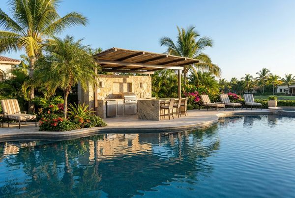 Poolside outdoor kitchen with a built-in grill and bar seating