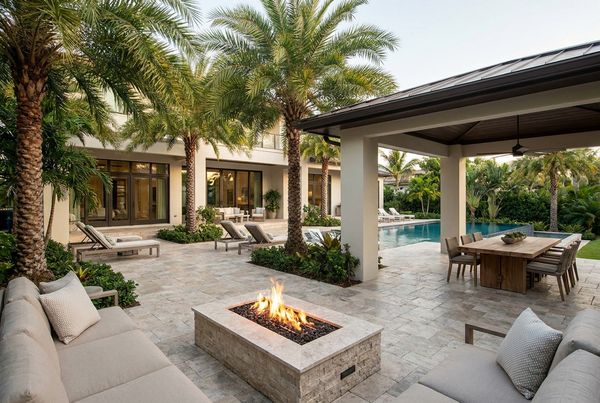 Backyard patio styled under a wood pergola with string lights