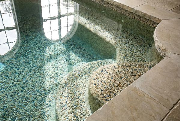 Pebble finish pool with a tanning ledge and clean coping