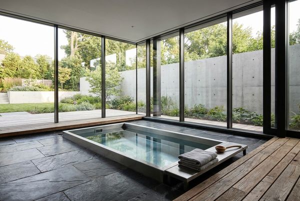 Stainless steel cold-plunge setup beside a warm spa for contrast therapy
