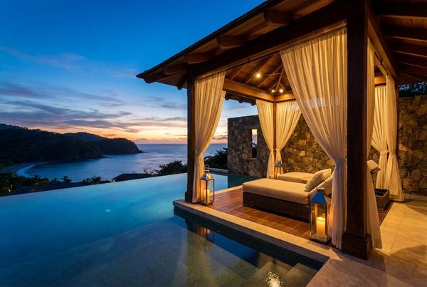 Pool cabana glowing at dusk with warm integrated lighting